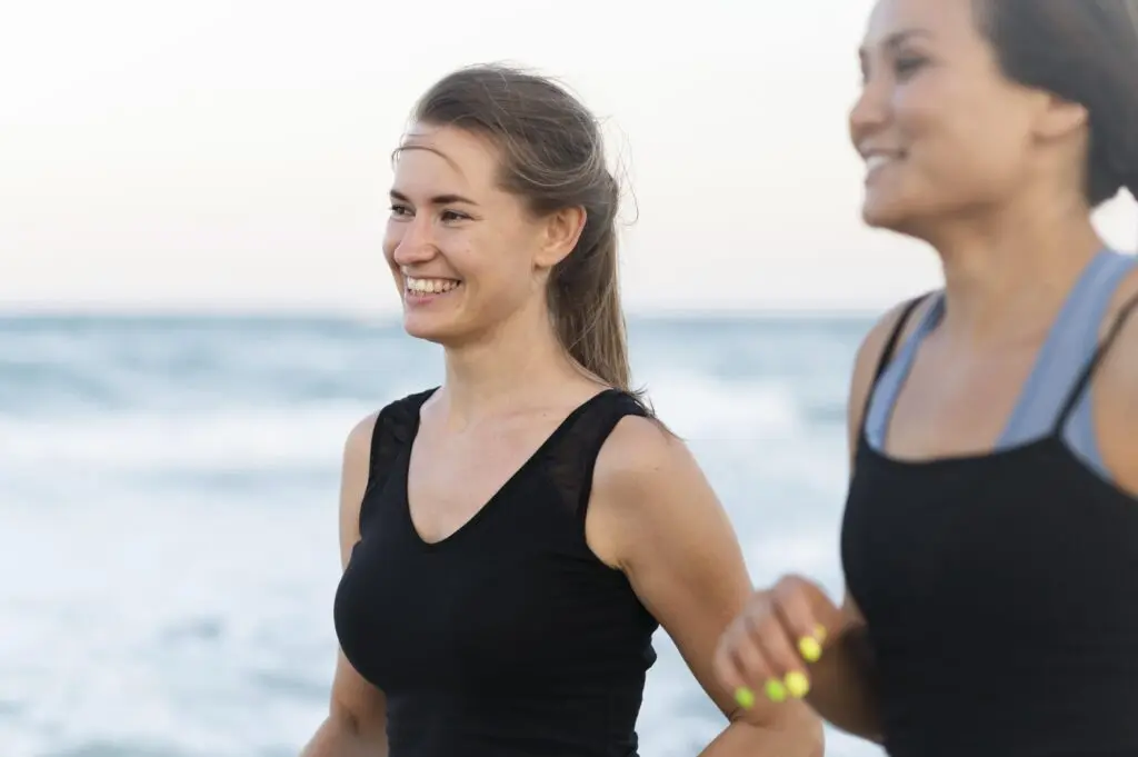 Side view smiley women exercising beach